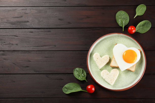 istock Flat lay composition of tasty breakfast with heart shaped fried egg. Space for text 1477275498