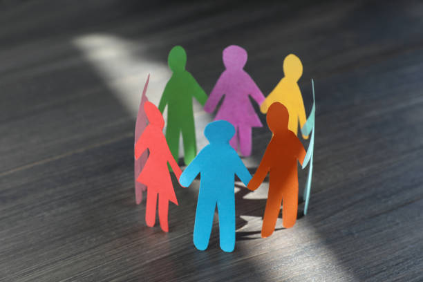 istock Paper human figures making circle on wooden table. Diversity and inclusion concept 1477277213