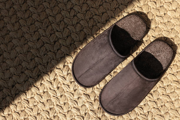 istock Pair of brown slippers on carpet, top view. Space for text 1477277246