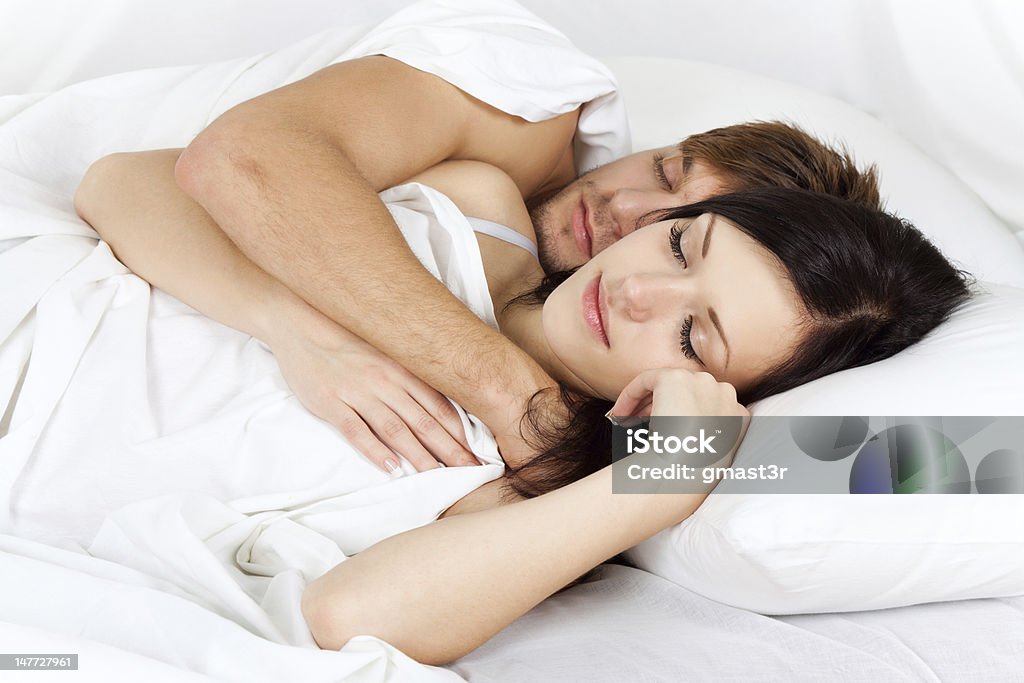 happy young couple in bed young lovely beautiful couple lying sleeping in a bed, closed eyes Adult Stock Photo