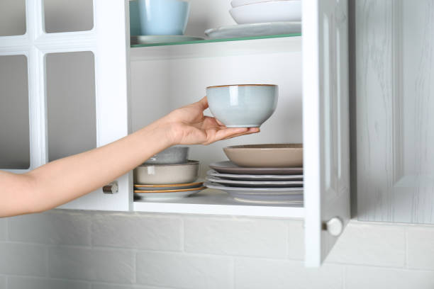 istock Woman taking ceramic bowl from cabinet at home, closeup 1477281841