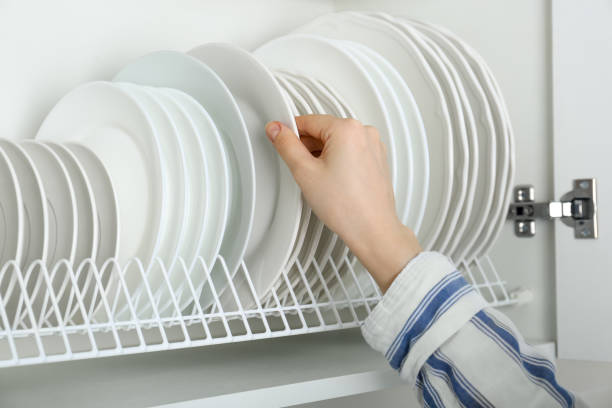 istock Woman taking ceramic plate from drying rack, closeup 1477281845