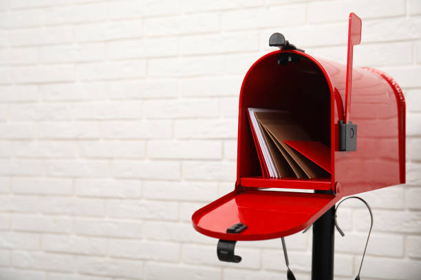 otwórz czerwoną skrzynkę pocztową z kopertami w pobliżu białej ceglanej ściany. miejsce na tekst - mailbox zdjęcia i obrazy z banku zdjęć