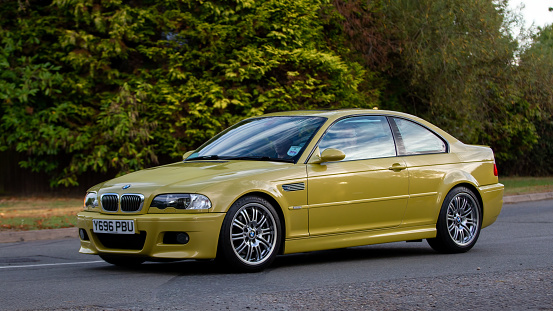 Whittlebury,Northants,UK - August 28th 2022. 2001 3246 cc BMW M3 in yellow car driving on an English country road