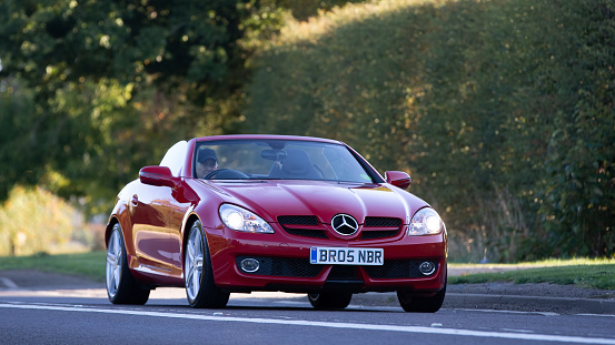 Bicester,Oxon,UK - Oct 9th 2022. 2010 red MERCEDES BENZ SLK convertible car driving on an English country road