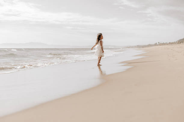 istock Cute child strolling on sandy seashore on sunny day 1477291548