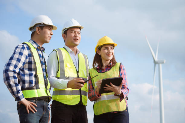 zespół azjatyckich inżynierów omawia i sprawdza turbiny na farmie wiatrowej. technologia energii odnawialnej i zrównoważony rozwój. - alternative energy electricity wind turbine team zdjęcia i obrazy z banku zdjęć