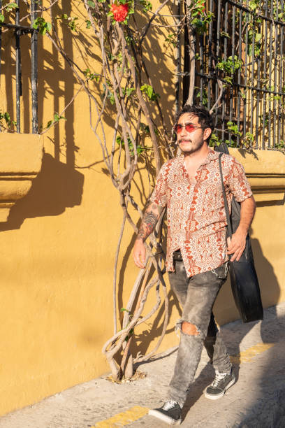 istock Latin man with guitar walking on the street 1477299840