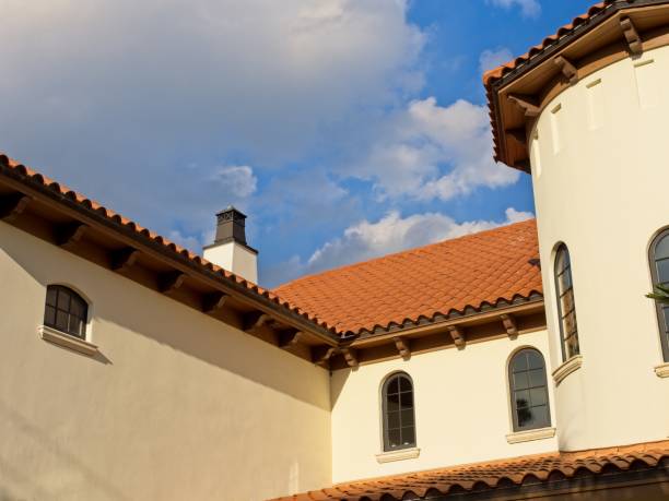istock Terracotta tile roof line on Spanish architectural design home with blue sky background 1477301424