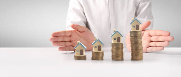 istock House Residential Structure in hand ,model house and coin 1477307343