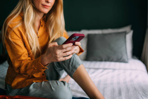 istock An Unrecognizable Happy Beautiful Blonde Businesswoman Texting On Her Mobile Phone While Relaxing At Home 1477307912