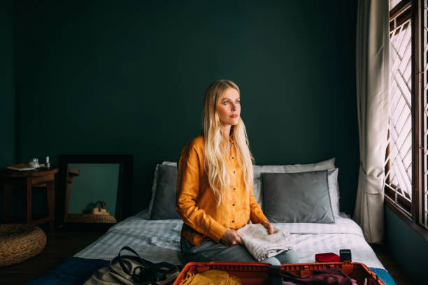 istock A Happy Beautiful Blonde Woman Looking Away While Packing Her Suitcase For A Trip 1477307949