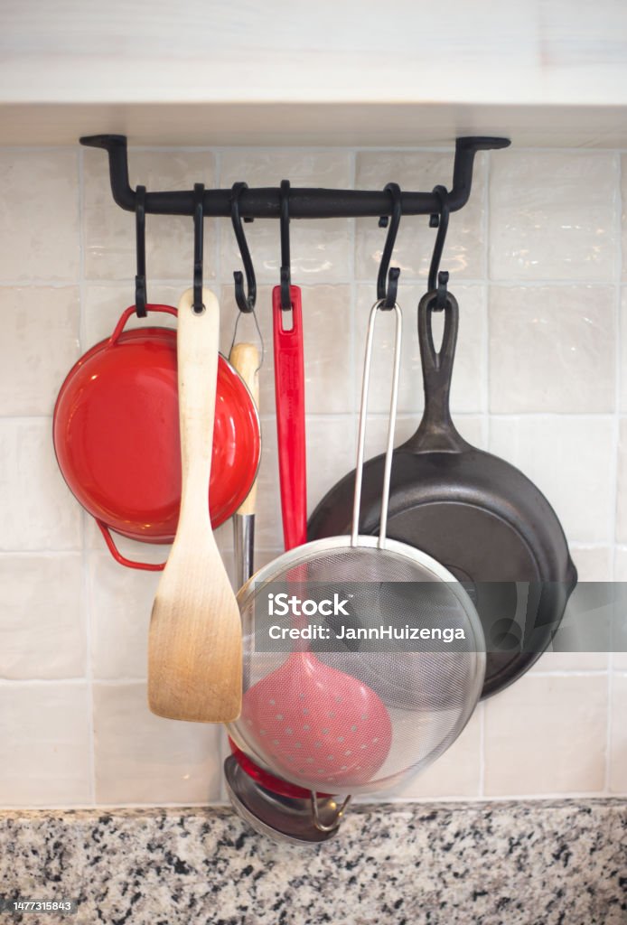 Kitchen Rack with Frying Pans, Utensils, Strainer Colander Stock Photo
