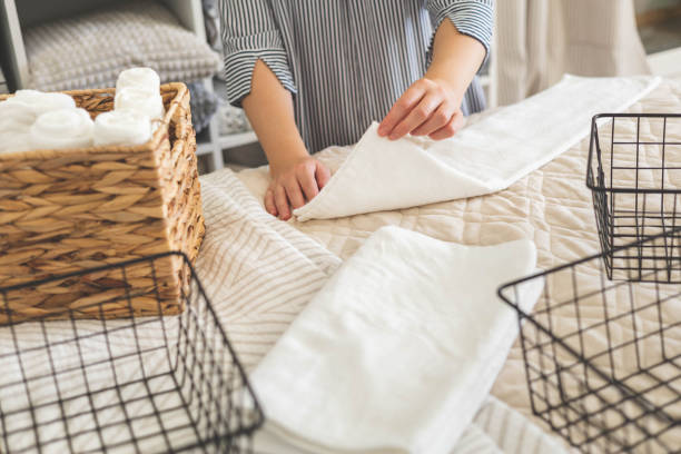 istock Top view female hands neatly folded white clean towels in case box use Japanese organizing method 1477318721