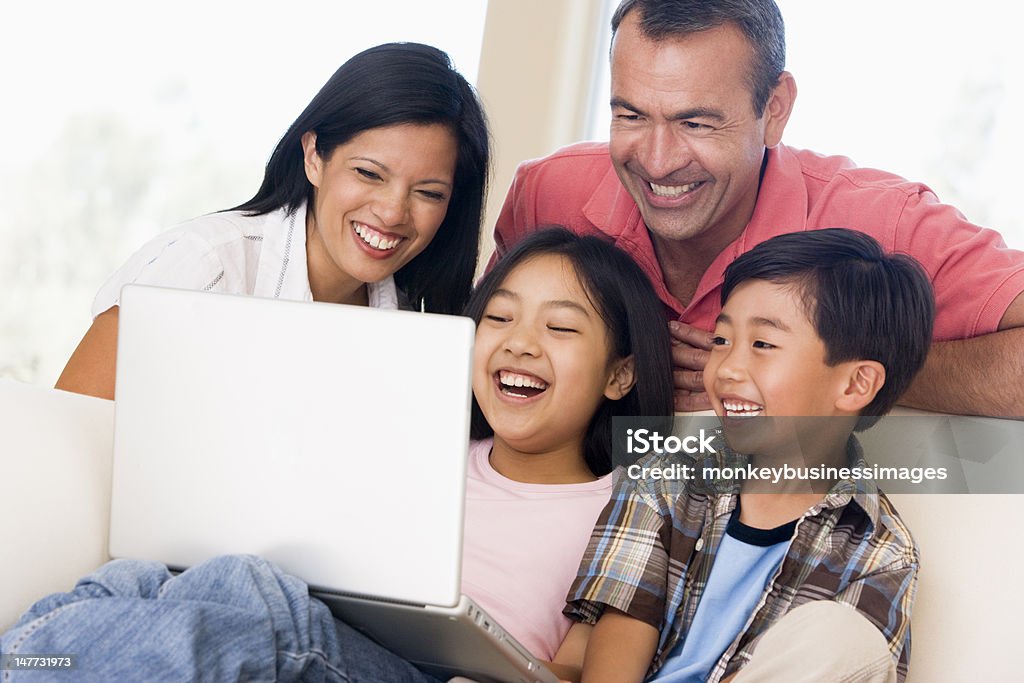 Família na sala de estar com laptop a sorrir - Royalty-free Criança Foto de stock