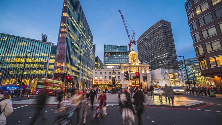 Time lapse of Crowd pedestrian and tourist walking and crossing road with traffic light and beautiful scenery city around Victoria Station in London at night, United Kingdom