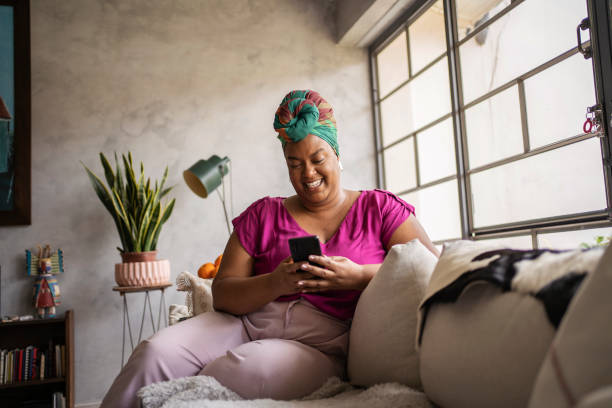 Black mature woman using smart phone stock photo