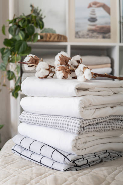 istock Cotton branch with pile of folded bed sheets and blankets 1477349615