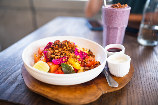 Close-up of exotic fruit salad with muesli granola and berry’s smoothie