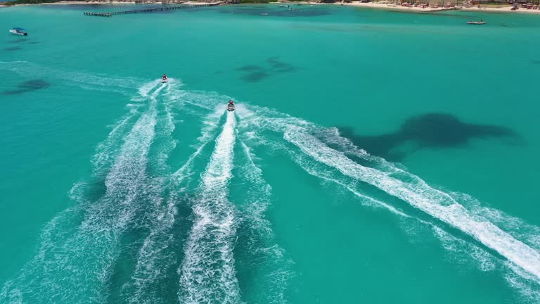 Aerial view of riding people on jet ski (personal watercraft). Caribbean beach on Cancun hotel zone, Mexico.