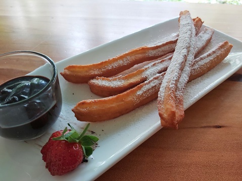 Close up photo of churros with chocolate sauce