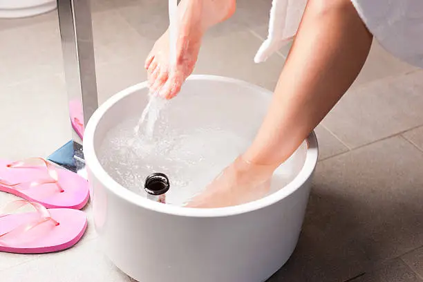 Woman having hydrotherapy water footbath in spa setting