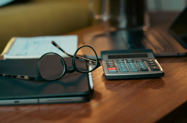 istock counting bills, accountant table with glasses and calculator 1477376948