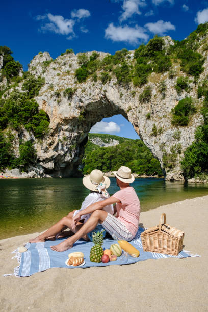 couple en vacances en ardèche france pont d’arc, vue de l’arc de narural pont d’arc canyon france - canoeing people traveling camping couple photos et images de collection