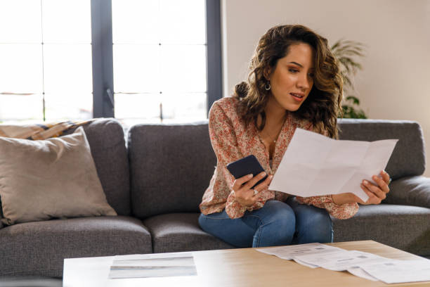 istock Young woman using smart phone when paying her financial bills 1477388579