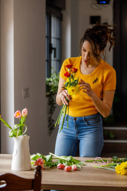 istock Young woman arranging beautiful spring flowers in a bouquet 1477389556