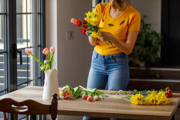 istock Young woman arranging beautiful spring flowers in a bouquet 1477389558