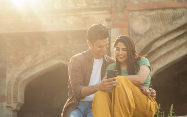 istock Cheerful couple having fun using phone at historic site 1477391989
