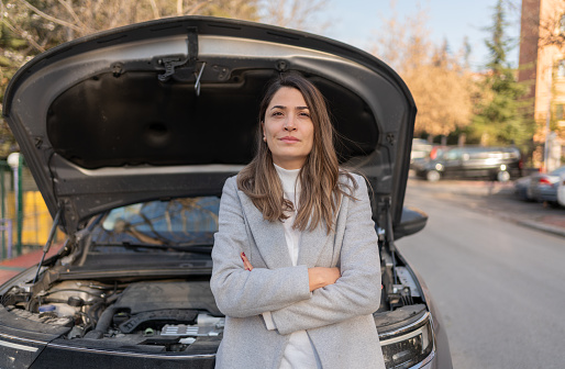 A Woman In Front Of A Broken Car