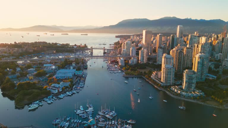 Vancouver downtown skyline aerial flythrough over marina, BC, Canada at sunset