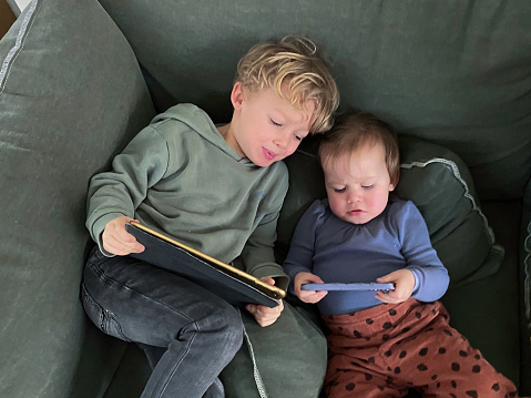 Toddler boy with his baby sister goes digital