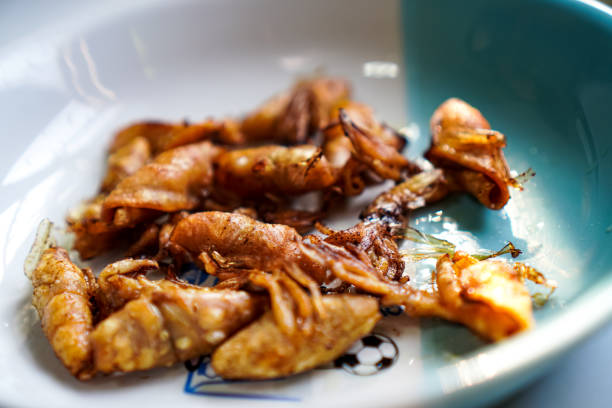 istock A side-view close-up shows a group of small squids being deep-fried and placed on a ready-to-eat plate. 1477411186
