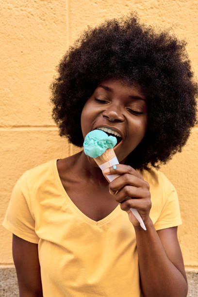 istock African woman licking a blue ice cream 1477411200