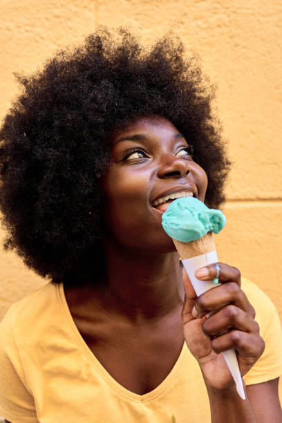 istock Distracted african woman eating an ice cream 1477411239