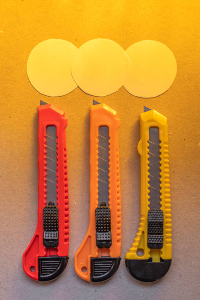 istock Red and orange sharp office stationery knife brown a cardboard cutting blade on a desktop office desk 1477415972
