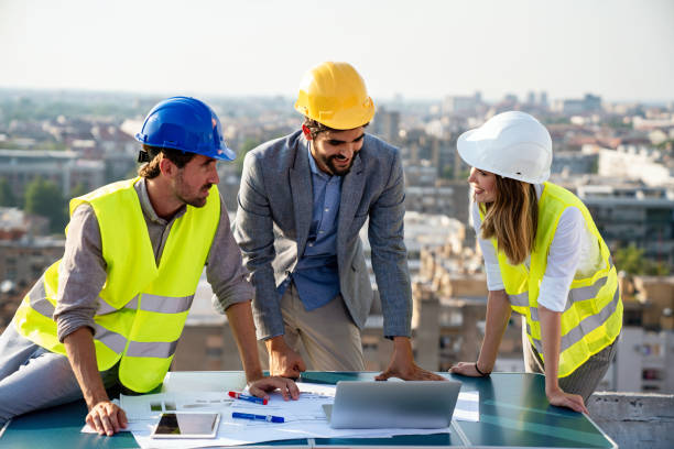 istock Group of engineers, architects, business partners at construction site working together 1477421750