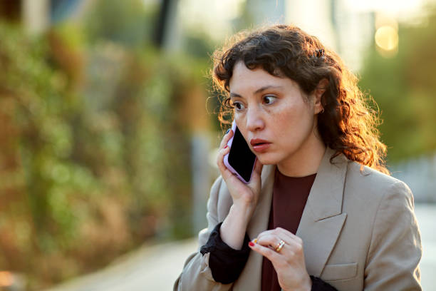 Zaniepokojona bizneswoman korzystająca z telefonu na zewnątrz – zdjęcie