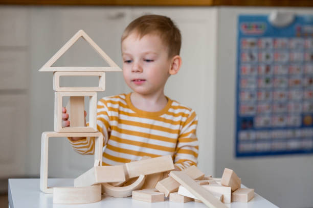 istock A little boy of 3 years old is playing a developing logistics constructor. Children's wooden toys. Montessori for child development. 1477424495