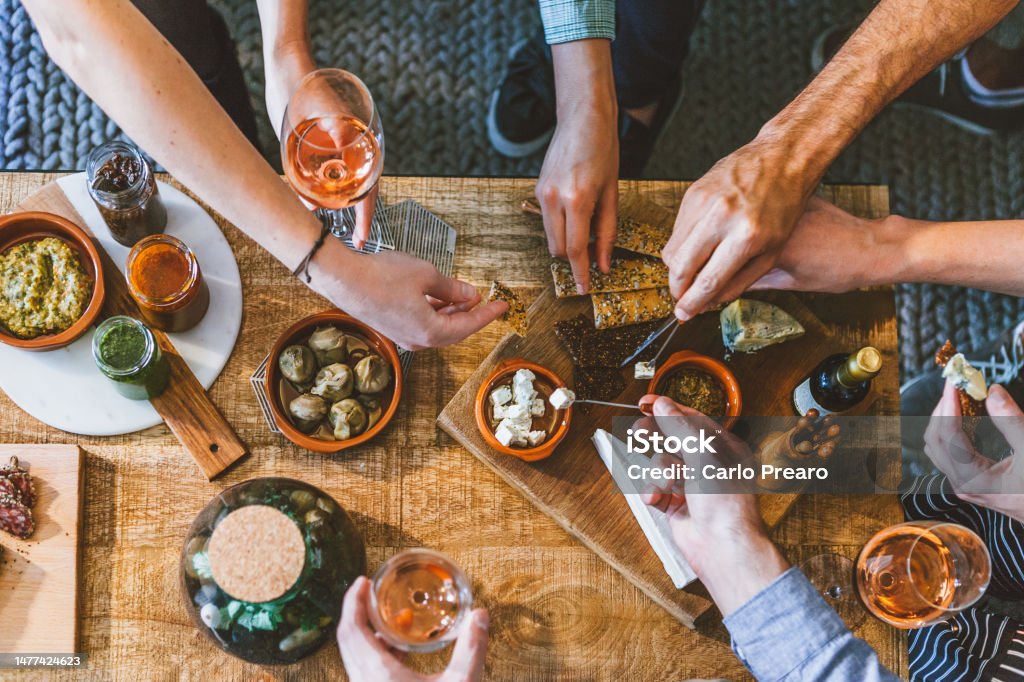 Vue de dessus d’un groupe de personnes autour d’une table dégustant de la nourriture et de l’amitié - Photo de Apéritif libre de droits