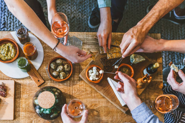 食べ物と友情を楽しむテーブルの周りの人々のグループのトップビュー - 食前酒 ストックフォトと画像