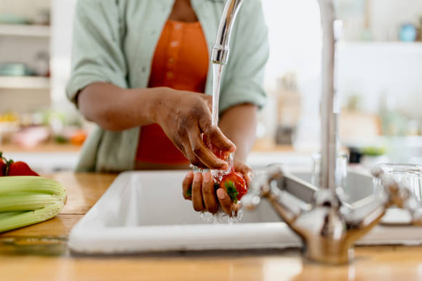 nahaufnahme einer frau, die erdbeeren in der küche wäscht - washing fruit preparing food strawberry stock-fotos und bilder