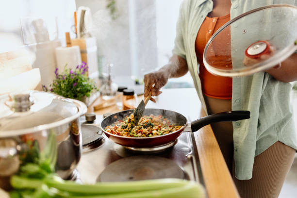 istock Woman preparing quinoa vegetable mix cooked in a frying pan 1477430984