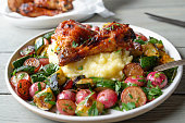 Roasted vegetables with glazed barbecue chicken drumsticks  and mashed potatoes on a plate