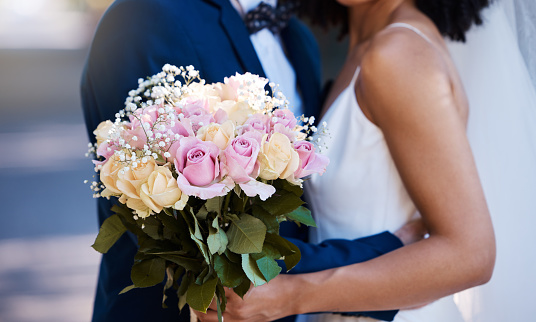 Flowers, wedding or marriage with a bride and groom outdoor together after a ceremony of traition or celebration. Bouquet, reception or commitment with a married couple outside as husband and wife