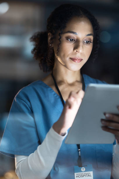 病院の医療用タブレット、看護師、黒人女性が遠隔医療、研究、またはオンライン相談に遅れて働いています。テクノロジー、ヘルスケア、または夜間のクリニックでのウェルネスアプリ用� - women science service technology ストックフォトと画像