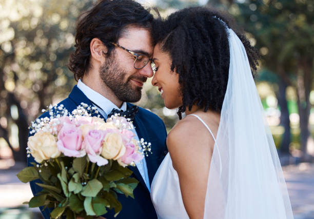 istock Married couple, flower and forehead with smile for wedding, marriage or loving commitment in the park. Happy groom and bride smiling in happiness for honeymoon, romance and embracing relationship 1477435936
